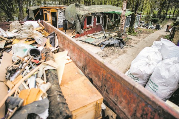 Eine Mulde mit entsorgten Teilen steht vor der bereits zum Teil abgerissenen Parzelle des mutmaßlichen Täters auf dem Campingplatz Eichwald im Ortsteil Elbrinxen. - © dpa