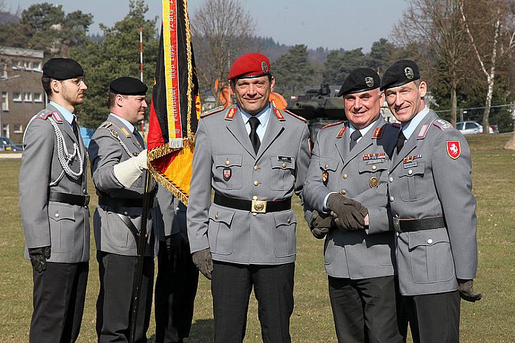 Übergabe vor der Truppenfahne: General Harald Gante (vorn links) verlässt die Panzerbrigade 21 "Lipperland. Oberst Kai Ronald Rohrschneider (rechts) ist sein Nachfolger. In der Mitte: Divisionskommandeur General Carsten Jacobson. - © Foto: Preuss