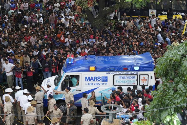 Ein Krankenwagen bahnt sich den Weg durch eine Menschenmenge am M. Chinnaswamy-Stadion in der indischen Stadt Bengaluru. - © Aijaz Rahi/AP/dpa