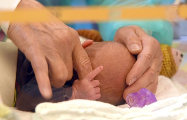 In einer Geburtsklinik hält ein erst wenige Stunden altes Baby den Finger seiner Mutter fest. (Symbolbild) - © Waltraud Grubitzsch/dpa