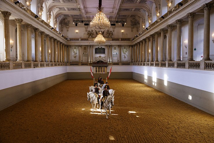 Die Vorführungen der Spanischen Hofreitschule, an denen auch Paula Behrens (4. von vorne) mitwirkt, finden in der barocken Halle der Winterreitschule mitten in Wien statt. - © Peter Rigaud