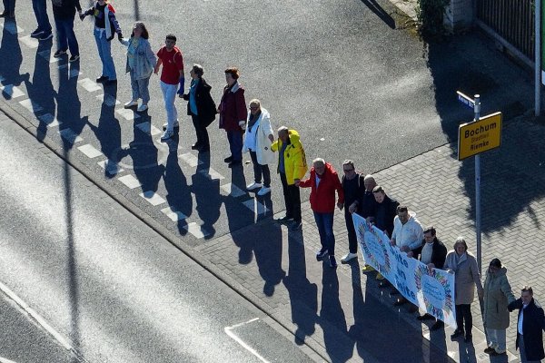 Teilnehmer einer Kundgebung für Demokratie und gegen die AfD bilden eine sieben Kilometer lange Menschenkette zwischen Bochum und Herne. - © Christoph Reichwein/dpa