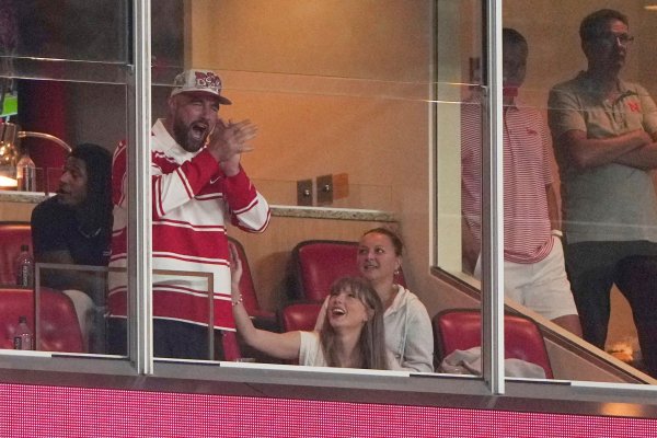 Er jubelt, sie wirft ihm einen verliebten Blick zu: Travis Kelce und Taylor Swift bei einem College-Football-Spiel. - © Charlie Riedel/AP/dpa