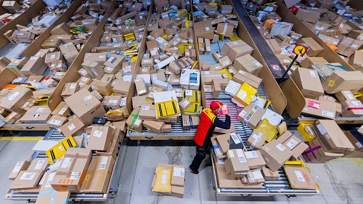 Ein Zusteller sortiert in einer Zustellbasis Pakete. Rund um Weihnachten herrscht bei der Deutschen Post und DHL Hochbetrieb. - © picture alliance/dpa