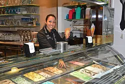 In der Eisdiele "Dolomiti" in der Salzufler Innenstadt wird das Eis noch selbst hergestellt. Viele Kunden bevorzugen die eigene Herstellung durch gelernte Eiskonditoren. Mitarbeiterin Schaiane Garcia reicht t&auml;glich unz&auml;hlige der fruchtigen oder nussigen Eiskugeln &uuml;ber den Tresen. - &copy; Tanja Watermann