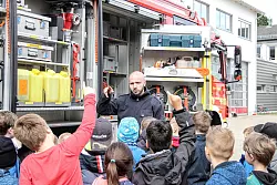 W&auml;hrend Andreas Weilacher von der Feuerwehr Detmold die Ausstattung eines L&ouml;schfahrzeugs zeigt, m&uuml;ssen die Kinder immer wieder einzelne Gegenst&auml;nde und ihre Verwendung erraten. - &copy; Niklas B&ouml;hmer