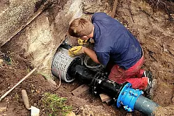 Lucas Gesel sorgt daf&uuml;r, dass die neue Rohrleitung fest in der Hauswand verankert ist.