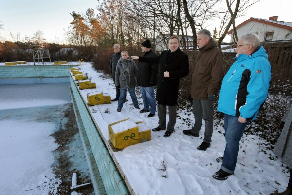 Nah dran: Bürgermeister Dr. Andreas Wulf erläutert beim Rundgang mit Bürgern kritische Punkte des Augustdorfer Freibads. Im Hintergrund ist links der Sprungturm, rechts die nahe angrenzende Wohnbebauung zu sehen. - © Bernhard Preuss