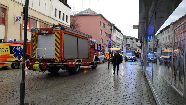 Einsatzkräfte von Feuerwehr und Rettungsdienst stehen am Freitag in der Innenstadt am Einsatzort. - © -/Zema Medien/dpa
