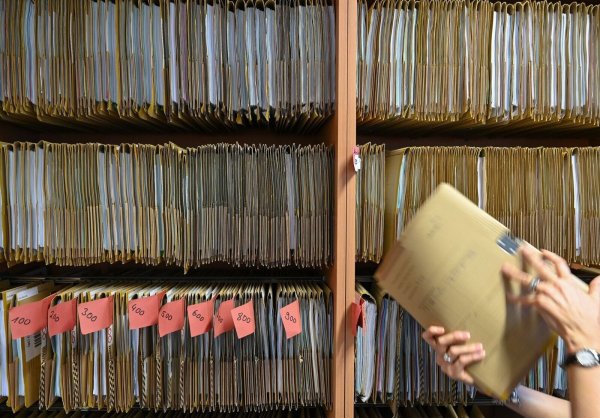 Eine Mitarbeiterin des Amtsgerichts Frankfurt greift an einem Regal nach einer Gerichtsakte. Der digitale Wandel in der hessischen Justiz ist mit der Einführung der E-Akte ein weiteres Stück vorangekommen. - © Arne Dedert/dpa