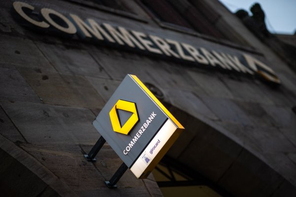 Das Logo der Commerzbank hängt an der Außenfassade einer Filiale. - © Daniel Karmann/dpa