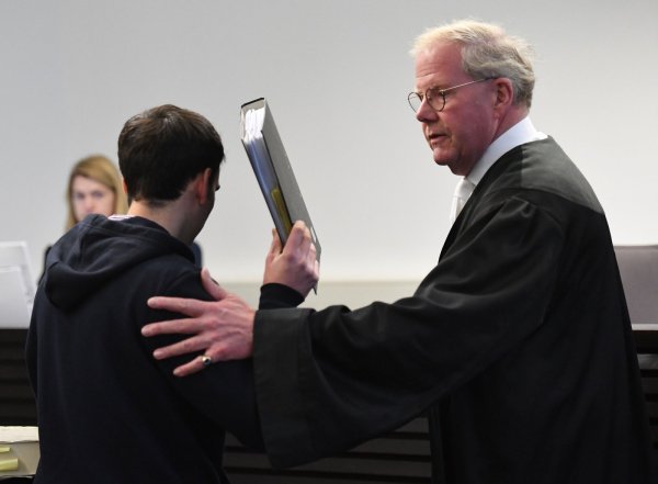 Angeklagt: Der 26-Jährige verbirgt sein Gesicht hinter einem Ordner, als er den Gerichtssaal betritt. - © Marc Köppelmann