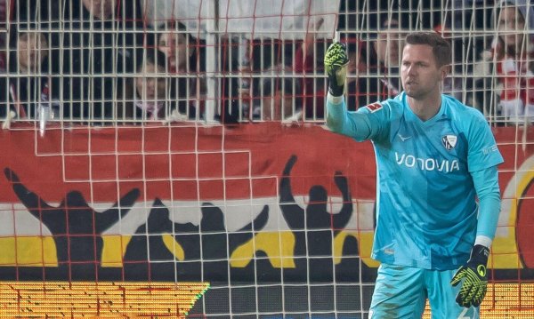 Bochums Keeper Patrick Drewes hält das Feuerzeug hoch, das ihn getroffen hat. - © Andreas Gora/dpa