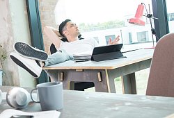 Mann schaut an seinem Schreibtisch aus dem Fenster - Christin Klose/dpa-tmn