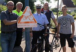 Geisterschild: Fahrradbeauftragter Jürgen Deppemeier, die Polizisten Heinz-Josef Fischer und Jürgen Hampe, Ordnungsamtsleiter Hans-Jürgen Taron und Bauhofauszubildender Christoph Freund (von links) präsentieren das Schild gegen "Geisterradfahrer". - Dohna