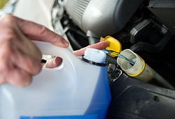 Mann füllt Frostschutzmittel im Auto nach - Andrea Warnecke/dpa-tmn