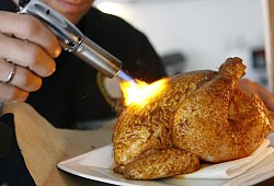 Ein H&auml;hnchen mit einem Bunsenbrenner br&auml;unen - Franz-Peter Tschauner/dpa/dpa-tmn