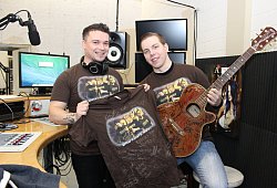 Hoffen auf hohe Gebote: Johannes Schuurmans (links) und Laurent Ohmansiek versteigern ein signiertes T-Shirt und eine Gitarre. Der Erl&ouml;s ist f&uuml;r eine Kinderkrebsstation in Minden bestimmt. - Grote