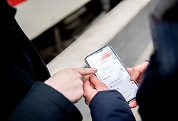 Zwei Personen bedienen die DB-App - Zacharie Scheurer/dpa-tmn