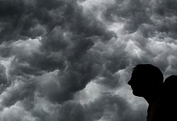 Ein Mann steht unter einem stürmischen Himmel - Julian Stratenschulte/dpa/dpa-tmn