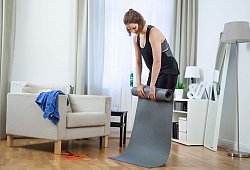 Eine Frau rollt eine Trainingsmatte zusammen - Christin Klose/dpa-tmn