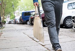 Mann tr&auml;gt seine Einl&auml;ufe in einem Baumwollbeutel - Andrea Warnecke/dpa-tmn