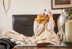 Eine Frau mit einer Erkältung auf einem Sofa - Christin Klose/dpa-tmn