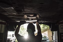 Ein KFZ-Mechaniker schaut sich ein Auto von unten an - Robert Günther/dpa-tmn