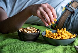 Mann isst auf einem Sofa Chips - Laura Ludwig/dpa-tmn