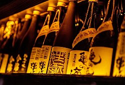 Sakeflaschen aneinandergereiht. - Zacharie Scheurer/dpa-tmn