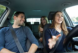 Drei Leute sitzen ausgelassen in einem Auto - Christin Klose/dpa-tmn