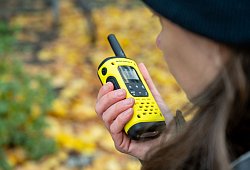 Eine Frau spricht in ein Walkie-Talkie in ihrer Hand - Nico Tapia/dpa-tmn