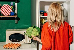 Eine Frau h&auml;lt einen Kohl vor einem offenen K&uuml;hlschrank - Vira Simon/Westend61/dpa-tmn