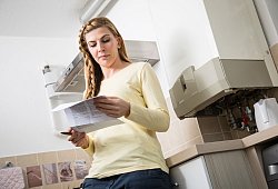 Frau liest Brief zum Anbieterwechsel eines Energieversorgers - Christin Klose/dpa-tmn