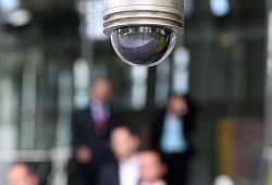 Mitarbeiter laufen unter einer &Uuml;berwachungskamera entlang - Oliver Berg/dpa/dpa-tmn