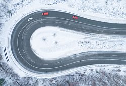 Autos fahren bei winterlichem Wetter eine Serpentine entlang - Sebastian Kahnert/dpa/dpa-tmn