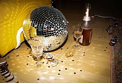 Discokugel liegt neben Sektflaschen und Gl&auml;sern auf dem Boden - Christin Klose/dpa-tmn