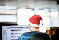 Ein Mann sitzt mit einer Weihnachtsmütze in Büro - Zacharie Scheurer/dpa-tmn