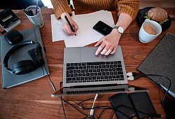 Frau arbeitet an einem Laptop - Fabian Strauch/dpa/dpa-tmn