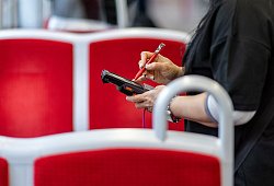 Eine Fahrkartenkontrolleurin kontrolliert einen Fahrgast - Daniel Karmann/dpa/dpa-tmn