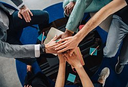 Gruppe Kolleginnen und Kollegen legen die H&auml;nde aufeinander - Zacharie Scheurer/dpa-tmn