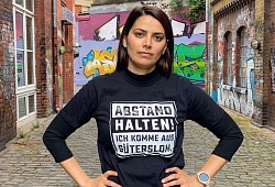 Die Gütersloherin Sarah Özdemir präsentiert das T-Shirt an der Weberei. - informa music & media GmbH