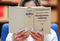 Eine Juristin liest in der Strafprozessordnung (StPO) - Oliver Berg/dpa/dpa-tmn