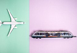 Ein Modellflugzeug und ein Modellzug auf farbigen Hintergrund - Zacharie Scheurer/dpa-tmn