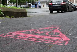 Das Geisterradler-Piktogramm verdeutlicht: Hier bist du falsch. Im Hintergrund sprechen die Polizisten Roger Berkel und Jörg Thelaner Radfahrer an, die an der Paulinenstraße auf dem Bürgersteig unterwegs sind. - Jost Wolf