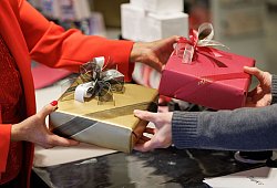 Eingepackte Geschenke werden in einem Geschäft überreicht - Friso Gentsch/dpa