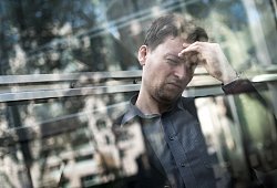 Mann hält sich mit der Hand seinen schmerzenden Kopf - Alexander Heinl/dpa-tmn