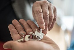 Eine Frau übergibt einen Wohnungsschlüssel - Ole Spata/dpa-tmn