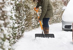 Eine Frau schippt Schnee auf dem Gehweg vor ihrem Haus - Benjamin Nolte/dpa-tmn