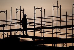 Silhouette eines Bauarbeiters auf einer Baustelle - Julian Stratenschulte/dpa/dpa-tmn